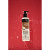 Shampoo Organic Shop Coco y Karité sobre fondo rojo con gotas de agua