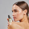 Mujer sosteniendo el sérum Naturaloe de 30 ml junto al rostro