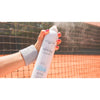 Mano aplicando el spray de agua termal Byphasse al aire libre