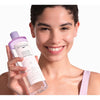 Mujer sonriendo con la solución micelar bifásica Byphasse en la mano