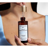 Manos sosteniendo el frasco con pipeta del sérum Byphasse