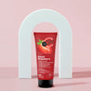 Tubo de exfoliante Sweet Strawberry Skin Super Good frente a un arco blanco