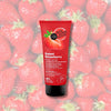 Exfoliante corporal de frutilla Skin Super Good sobre un fondo de frutillas